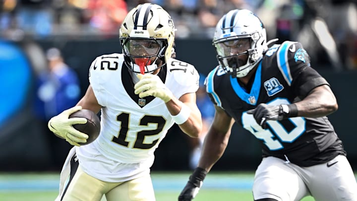 New Orleans Saints wide receiver Chris Olave (12) with the ball as Carolina Panthers linebacker Charles Harris (40) defends in the first quarter at Bank of America Stadium.