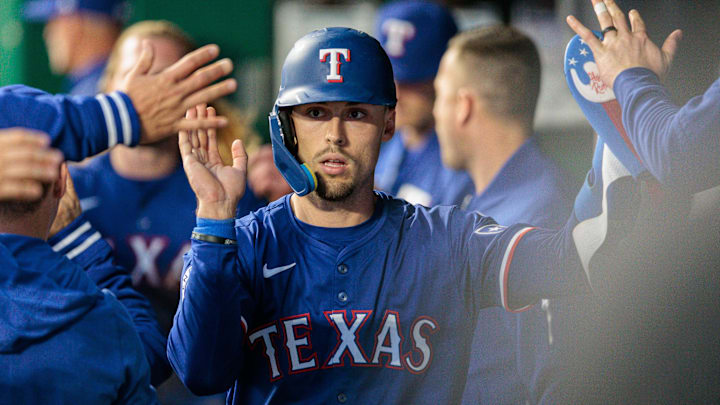 May 4, 2024; Kansas City, Missouri, USA; Texas Rangers outfielder Evan Carter (32) celebrates in the dugout after scoring during the seventh inning against the Kansas City Royals at Kauffman Stadium. 
