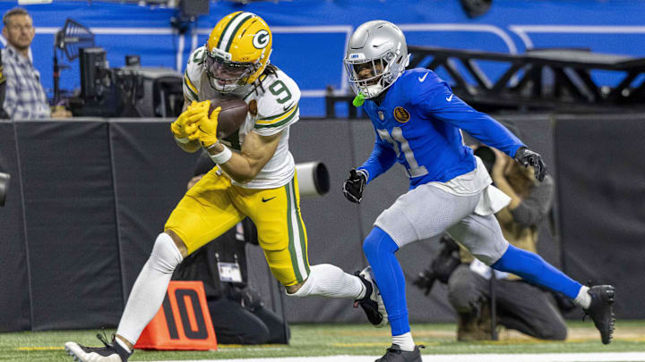 Green Bay Packers wide receiver Christian Watson (9) catches a pass against Detroit Lions cornerback Amik Robertson (21) during the third quarter at Ford Field.