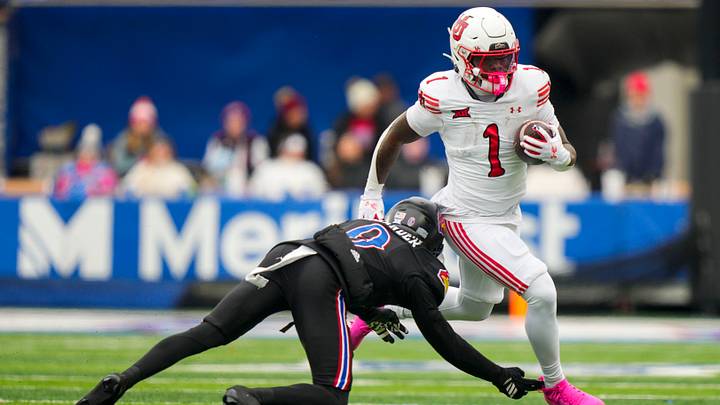 Nov 28, 2025; Lawrence, Kansas, USA; Utah Utes running back Wayshawn Parker (1) runs with the ball against Kansas Jayhawks defensive back Austin Alexander (0) during the second half at David Booth Kansas Memorial Stadium. Mandatory Credit: Jay Biggerstaff-Imagn Images Nov 28, 2025; Lawrence, Kansas, USA; Utah Utes running back Wayshawn Parker (1) runs with the ball against Kansas Jayhawks defensive back Austin Alexander (0) during the second half at David Booth Kansas Memorial Stadium. Mandatory Credit: Jay Biggerstaff-Imagn Images