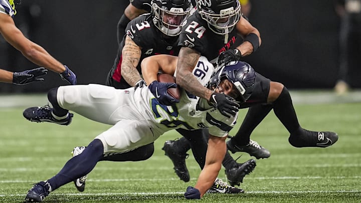 Dec 7, 2025; Atlanta, Georgia, USA; Seattle Seahawks running back Zach Charbonnet (26) is tackled by Atlanta Falcons safety Jessie Bates III (3) and cornerback A.J. Terrell Jr. (24) during the second half at Mercedes-Benz Stadium. Mandatory Credit: Dale Zanine-Imagn Images Dec 7, 2025; Atlanta, Georgia, USA; Seattle Seahawks running back Zach Charbonnet (26) is tackled by Atlanta Falcons safety Jessie Bates III (3) and cornerback A.J. Terrell Jr. (24) during the second half at Mercedes-Benz Stadium. Mandatory Credit: Dale Zanine-Imagn Images