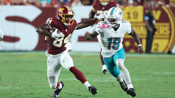 Washington Commanders wide receiver Jacoby Jones (84) runs with the ball as Miami Dolphins linebacker Kyle Louis (19) defends during the second half at Northwest Stadium.