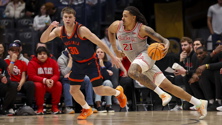 Feb 14, 2026; Nashville, Tennessee, USA;  Ohio State Buckeyes forward Devin Royal (21) drives to the basket past Virginia Cavaliers guard Dallin Hall (30) during the second half at Bridgestone Arena. Mandatory Credit: Steve Roberts-Imagn Images