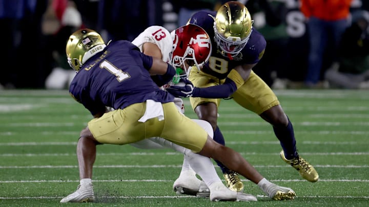 Notre Dame Fighting Irish safety Jordan Clark (1) and safety Adon Shuler (8) tackle Indiana Hoosiers wide receiver Elijah Sarratt (13) during the second half at Notre Dame Stadium.