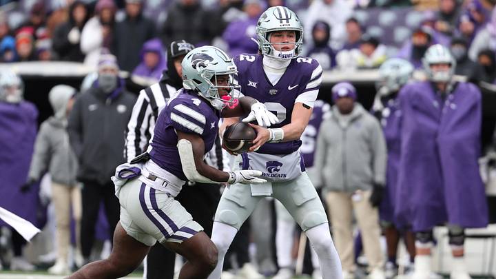 Nov 29, 2025; Manhattan, Kansas, USA; Kansas State Wildcats running back Joe Jackson (4) takes the handoff from quarterback Avery Johnson (2) during the fourth quarter at Bill Snyder Family Football Stadium. Mandatory Credit: Scott Sewell-Imagn Images