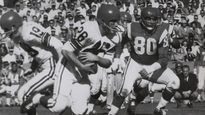 Jan 15, 1961; Los Angeles, CA, USA; FILE PHOTO; Baltimore Colts quarterback (19) JOHNNY UNITAS hands off to Los Angeles rams running back (26) JON ARNETT as New York Giants defensive end (80) ANDY ROBUSTELLI gives chase during the 1961 Pro Bowl at Memorial Coliseum.  
