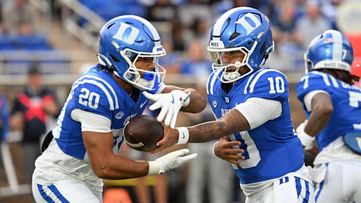 Nov 15, 2025; Durham, North Carolina, USA; Duke Blue Devils quarter back Darian Mensah (10) hands the ball to Duke Blue Devils running back Nate Sheppard (20) against the Virginia Cavaliers during the first quarter at Wallace Wade Stadium. Mandatory Credit: Zachary Taft-Imagn Images