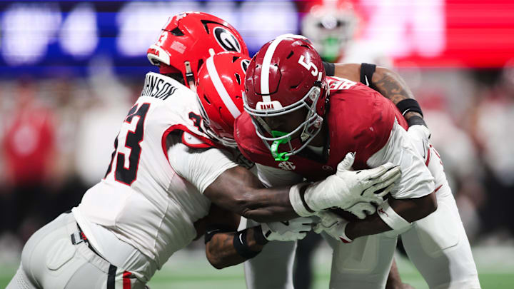 Dec 6, 2025; Atlanta, GA, USA; Alabama Crimson Tide wide receiver Germie Bernard (5) makes a catch as Georgia Bulldogs linebacker Quintavius Johnson (33) tackles during the fourth quarter during the 2025 SEC Championship game at Mercedes-Benz Stadium. Mandatory Credit: Brett Davis-Imagn Images