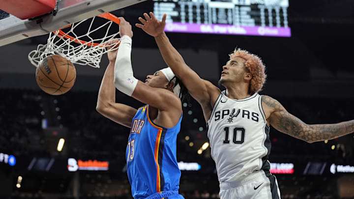 Oct 7, 2024; San Antonio, Texas, USA; Oklahoma City Thunder forward Ousmane Dieng (13) dunks while defended by San Antonio Spurs forward Jeremy Sochan (10) during the second half at Frost Bank Center.
