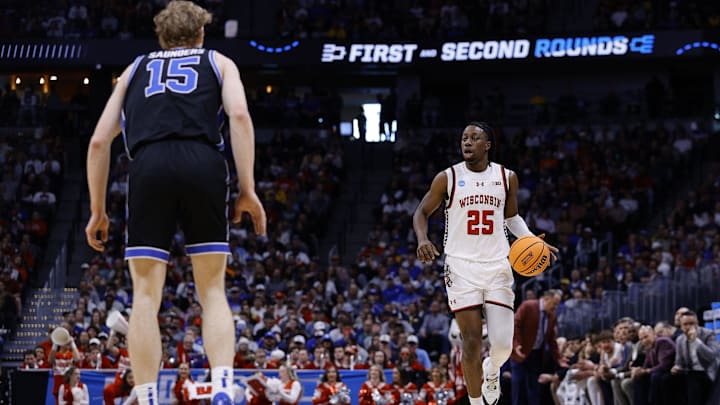 Mar 22, 2025; Denver, CO, USA; Wisconsin Badgers guard John Blackwell (25) dribbles the ball against Brigham Young Cougars forward Richie Saunders (15) during the first half in the second round of the NCAA Tournament  at Ball Arena. Mandatory Credit: Isaiah J. Downing-Imagn Images