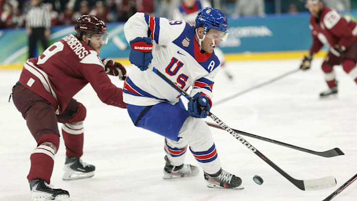Feb 12, 2026; Milan, Italy; Matthew Tkachuk of United States in action with Renars Krastenbergs of Latvia  in men's ice hockey group C play during the Milano Cortina 2026 Olympic Winter Games at Milano Santagiulia Ice Hockey Arena. Mandatory Credit: Geoff Burke-Imagn Images