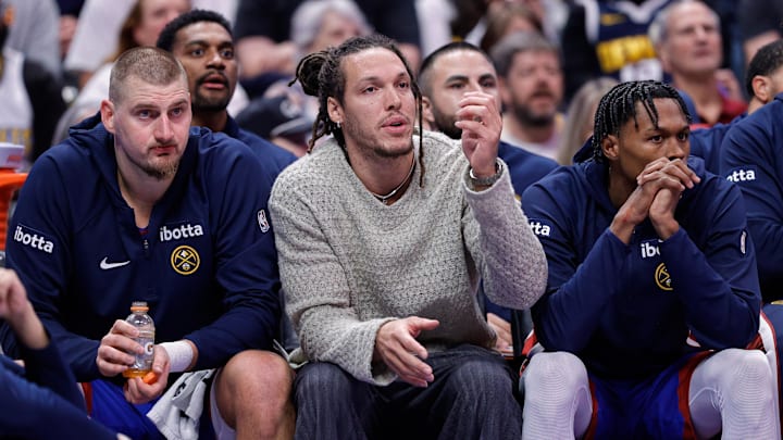 Nov 28, 2025; Denver, Colorado, USA; Denver Nuggets forward Aaron Gordon (C) looks on from the bench with center Nikola Jokic (15) and guard Peyton Watson (8) in the fourth quarter against the San Antonio Spurs at Ball Arena. Mandatory Credit: Isaiah J. Downing-Imagn Images