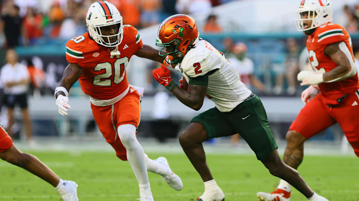 Sep 7, 2024; Miami Gardens, Florida, USA; Florida A&M Rattlers wide receiver Jamari Gassett (2) runs with the football against Miami Hurricanes defensive back Zaquan Patterson (20) during the second quarter at Hard Rock Stadium. Mandatory Credit: Sam Navarro-Imagn Images