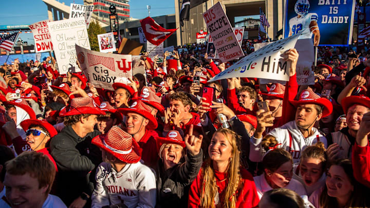 Fans hold signs during the Fox Big Noon Kickoff show outside of Memorial Stadium 