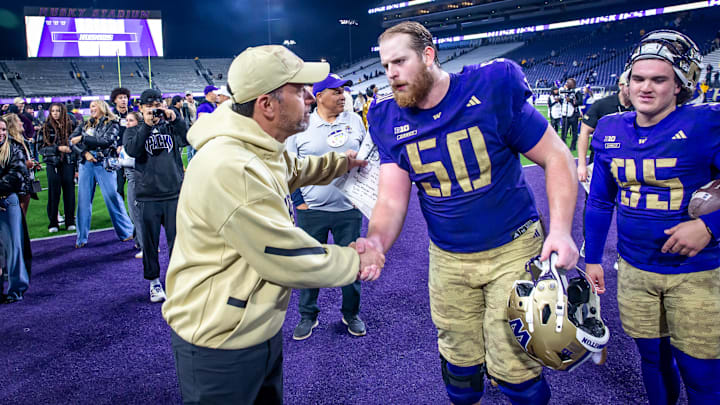 Jedd Fisch and tackle Carver Willis shake hands after the Purdue game, with kicker Grady Gross nearby. 