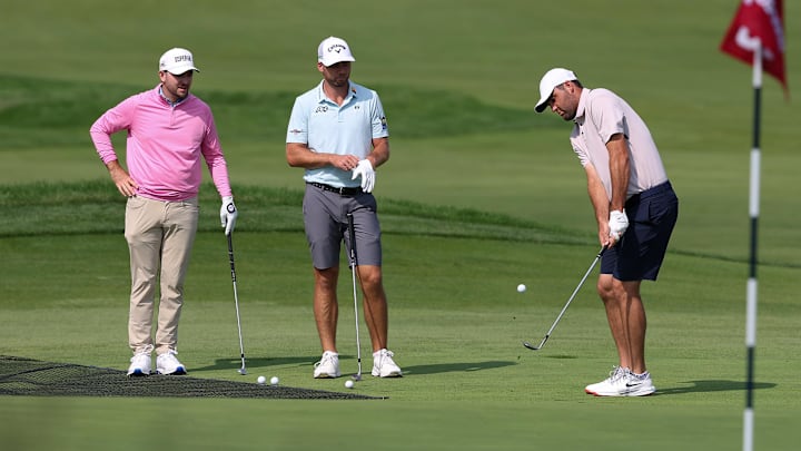 Jun 10, 2025; Oakmont, Pennsylvania, USA; Philip
Barbaree (L) and Sam Burns (M) watch Scottie Scheffler (R) chip onto the second hole during a practice round for the U.S. Open golf tournament at Oakmont Country Club. Mandatory Credit: Bill Streicher-Imagn Images