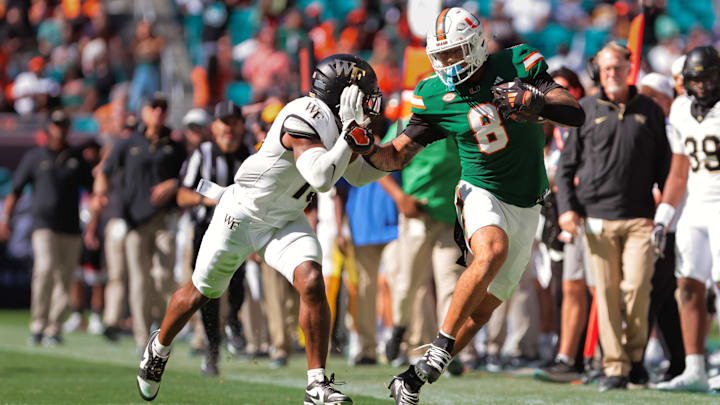 Nov 23, 2024; Miami Gardens, Florida, USA; Miami Hurricanes tight end Elijah Arroyo (8) runs with the football against Wake Forest Demon Deacons defensive back Davaughn Patterson (13) during the second quarter at Hard Rock Stadium. Mandatory Credit: Sam Navarro-Imagn Images Nov 23, 2024; Miami Gardens, Florida, USA; Miami Hurricanes tight end Elijah Arroyo (8) runs with the football against Wake Forest Demon Deacons defensive back Davaughn Patterson (13) during the second quarter at Hard Rock Stadium. Mandatory Credit: Sam Navarro-Imagn Images