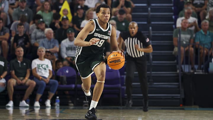 Nov 25, 2025; Fort Myers, Florida, USA; Michigan State Spartans guard Divine Ugochukwu (99) controls the ball against the East Carolina Pirates in the second half at Suncoast Credit Union Arena. Mandatory Credit: Nathan Ray Seebeck-Imagn Images Nov 25, 2025; Fort Myers, Florida, USA; Michigan State Spartans guard Divine Ugochukwu (99) controls the ball against the East Carolina Pirates in the second half at Suncoast Credit Union Arena. Mandatory Credit: Nathan Ray Seebeck-Imagn Images