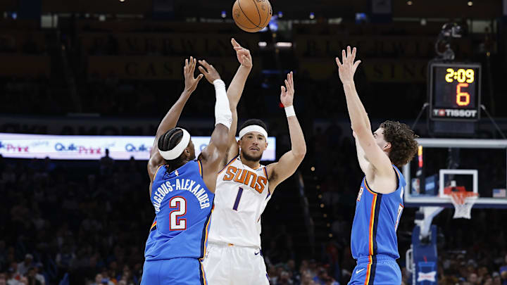 Apr 2, 2023; Oklahoma City, Oklahoma, USA; Phoenix Suns guard Devin Booker (1) passes the ball between Oklahoma City Thunder guard Shai Gilgeous-Alexander (2) and guard Josh Giddey (3) during the second half at Paycom Center. Phoenix won 128-118. Mandatory Credit: Alonzo Adams-Imagn Images Apr 2, 2023; Oklahoma City, Oklahoma, USA; Phoenix Suns guard Devin Booker (1) passes the ball between Oklahoma City Thunder guard Shai Gilgeous-Alexander (2) and guard Josh Giddey (3) during the second half at Paycom Center. Phoenix won 128-118. Mandatory Credit: Alonzo Adams-Imagn Images