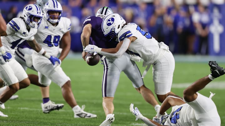Sep 21, 2024; Provo, Utah, USA; Brigham Young Cougars linebacker Aisea Moa (58) forces a fumble by Kansas State Wildcats quarterback Jacob Knuth (7) during the fourth quarter at LaVell Edwards Stadium. Mandatory Credit: Rob Gray-Imagn Images