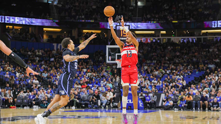Nov 10, 2024; Orlando, Florida, USA; Washington Wizards guard Jordan Poole (13) shoots a three point basket against Orlando Magic guard Cole Anthony (50) during the second quarter at Kia Center. Mandatory Credit: Mike Watters-Imagn Images