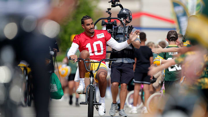 Green Bay Packers quarterback Jordan Love is followed by an NFL Films crew as he rides to practice on Friday.