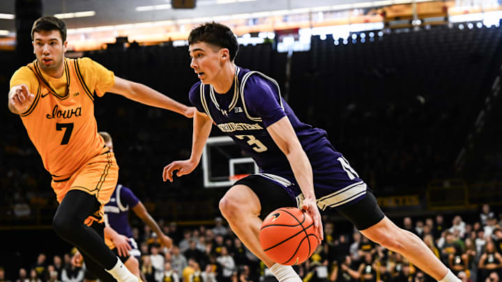 Feb 8, 2026; Iowa City, Iowa, USA; Northwestern Wildcats guard Jake West (3) goes to the basket as Iowa Hawkeyes forward Alvaro Folgueiras (7) defends during the first half at Carver-Hawkeye Arena. Mandatory Credit: Jeffrey Becker-Imagn Images