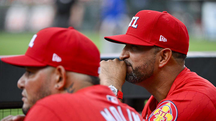 Aug 8, 2025; St. Louis, Missouri, USA;  St. Louis Cardinals manager Oliver Marmol (37) and guest coach Yadier Molina (4) look on from the dugout before a game against the Chicago Cubs at Busch Stadium. Mandatory Credit: Jeff Curry-Imagn Images