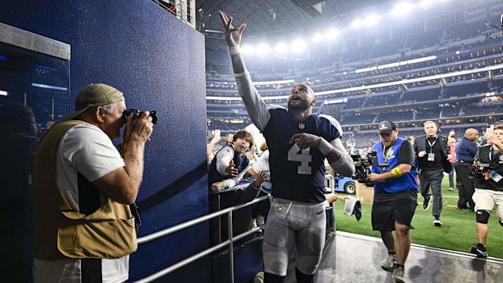 Dallas Cowboys QB Dak Prescott tosses his hat to the fans as he walks off the field after the game between the Cowboys and the New York Giants.