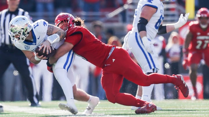 Louisville Cardinals defensive lineman Ashton Gillotte (9) brings down Kentucky Wildcats quarterback Devin Leary (13) for a sack in the first half Saturday. Nov. 25, 2023.
