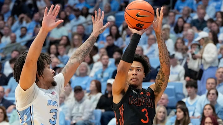 Mar 1, 2025; Chapel Hill, North Carolina, USA;  Miami (Fl) Hurricanes guard Jalil Bethea (3) shoots as North Carolina Tar Heels guard Elliot Cadeau (3) defends in the first half at Dean E. Smith Center. Mandatory Credit: Bob Donnan-Imagn Images