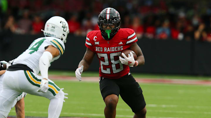 Oct 19, 2024; Lubbock, Texas, USA;  Texas Tech Red Raiders running back Tahj Brooks (28) runs the ball against Baylor Bears safety Corey Gordon Jr. (4) in the second half at Jones AT&T Stadium and Cody Campbell Field. Mandatory Credit: Michael C. Johnson-Imagn Images
