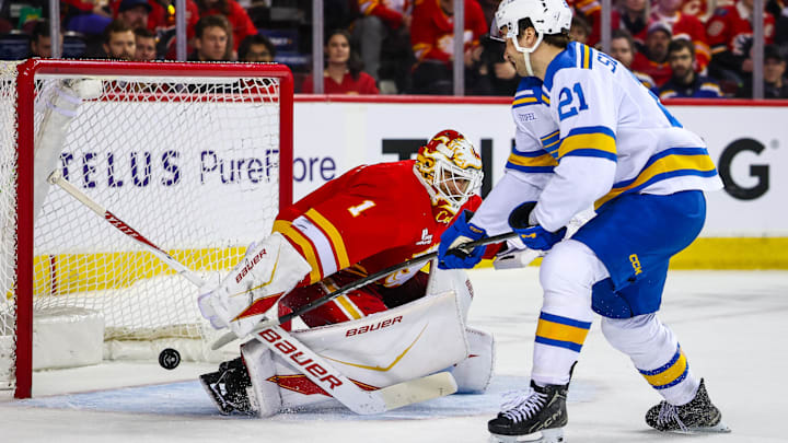 Mar 18, 2026; Calgary, Alberta, CAN; Calgary Flames goaltender Devin Cooley (1) makes a save against St. Louis Blues right wing Jimmy Snuggerud (21) during the shootout period at Scotiabank Saddledome. Mandatory Credit: Sergei Belski-Imagn Images