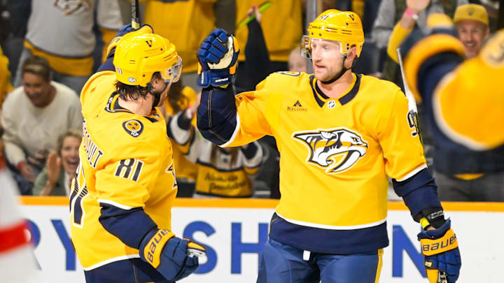 Oct 19, 2024; Nashville, Tennessee, USA;  Nashville Predators center Ryan O'Reilly (90) celebrates his goal with center Jonathan Marchessault (81) against the Detroit Red Wings Detroit Red Wings goaltender Cam Talbot (39) at Bridgestone Arena. Mandatory Credit: Steve Roberts-Imagn Images