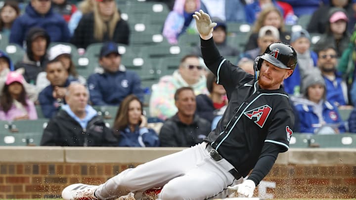 Apr 20, 2025; Chicago, Illinois, USA; Arizona Diamondbacks first baseman Pavin Smith (26) scores against the Chicago Cubs during the fourth inning at Wrigley Field. Mandatory Credit: Kamil Krzaczynski-Imagn Images
