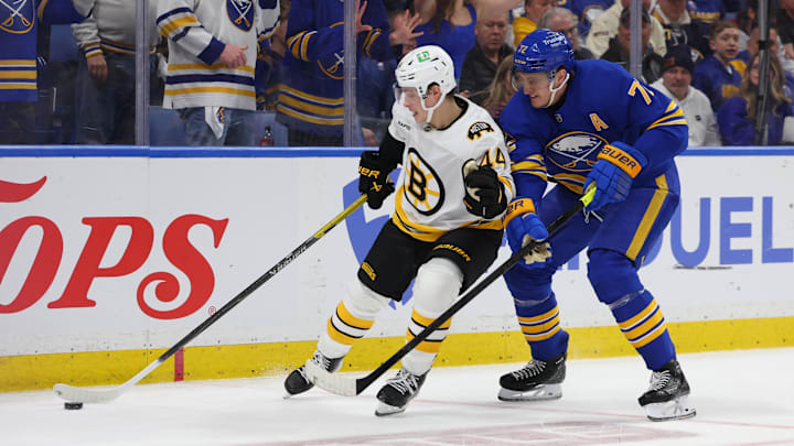 Apr 19, 2026; Buffalo, New York, USA; Boston Bruins center James Hagens (44) tries to control the puck as Buffalo Sabres center Tage Thompson (72) defends during the third period in game one of the first round of the 2026 Stanley Cup Playoffs at KeyBank Center. Mandatory Credit: Timothy T. Ludwig-Imagn Images