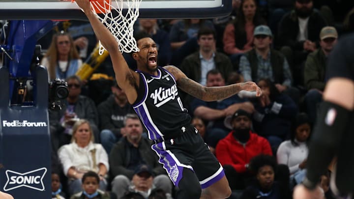 Dec 31, 2023; Memphis, Tennessee, USA; Sacramento Kings guard Malik Monk (0) reacts as he hangs from the rim after a dunk during the second half against the Memphis Grizzlies at FedExForum. Mandatory Credit: Petre Thomas-Imagn Images