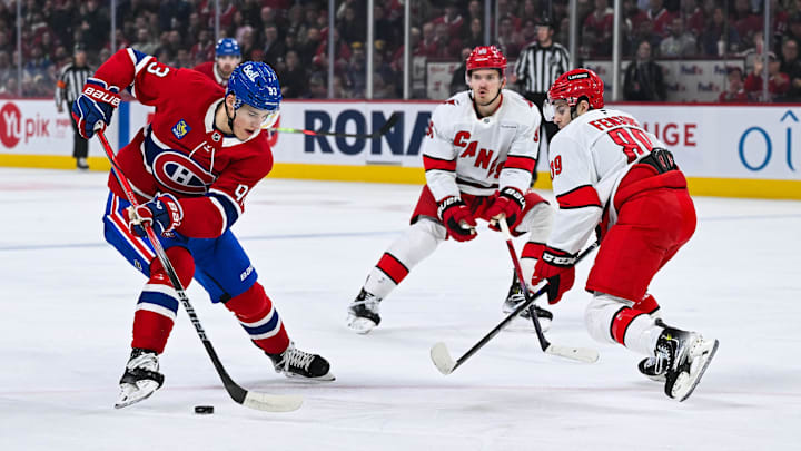 Apr 16, 2025; Montreal, Quebec, CAN; Montreal Canadiens right wing Ivan Demidov (93) plays the puck against Carolina Hurricanes defenseman Domenick Fensore (89) in the first period at Bell Centre. Mandatory Credit: David Kirouac-Imagn Images