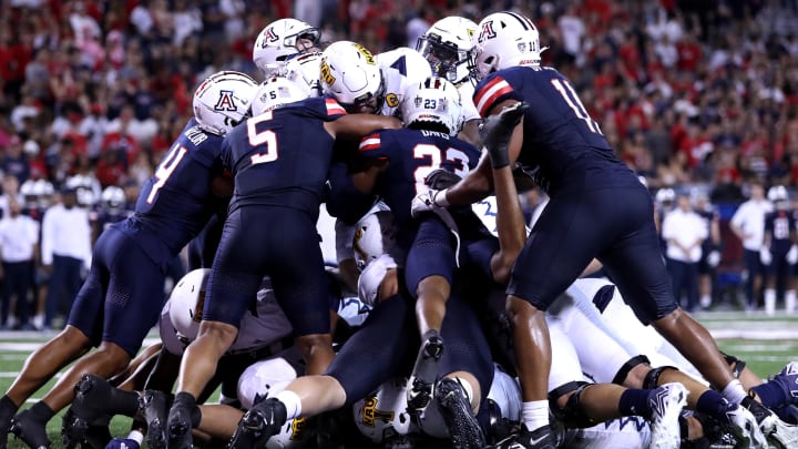 Sep 2, 2023; Tucson, Arizona, USA; Northern Arizona Lumberjacks quarterback Kai Millner (2) gets stopped at the goal line by Arizona Wildcats linebacker Jacob Manu (5), cornerback Tacario Davis (23), safety Isaiah Taylor (4), and linebacker Taylor Upshaw (11) during the second half at Arizona Stadium. Sep 2, 2023; Tucson, Arizona, USA; Northern Arizona Lumberjacks quarterback Kai Millner (2) gets stopped at the goal line by Arizona Wildcats linebacker Jacob Manu (5), cornerback Tacario Davis (23), safety Isaiah Taylor (4), and linebacker Taylor Upshaw (11) during the second half at Arizona Stadium.