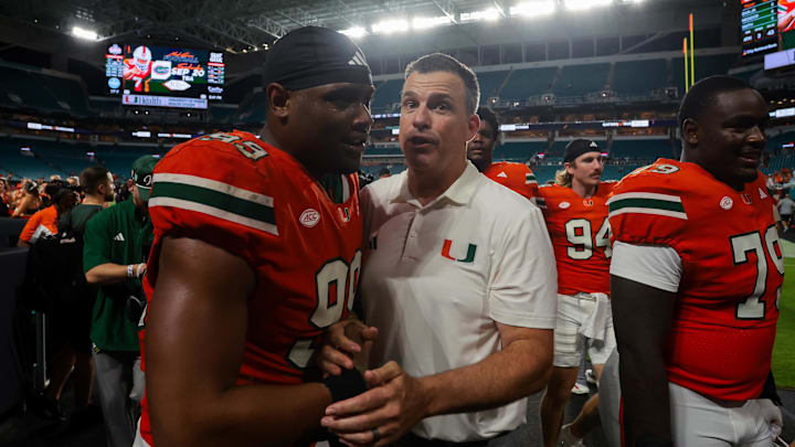 Sep 13, 2025; Miami Gardens, Florida, USA; Miami Hurricanes head coach Mario Cristobal celebrates with defensive lineman Ahmad Moten Sr. (99) after the game against the South Florida Bulls at Hard Rock Stadium. Mandatory Credit: Sam Navarro-Imagn Images