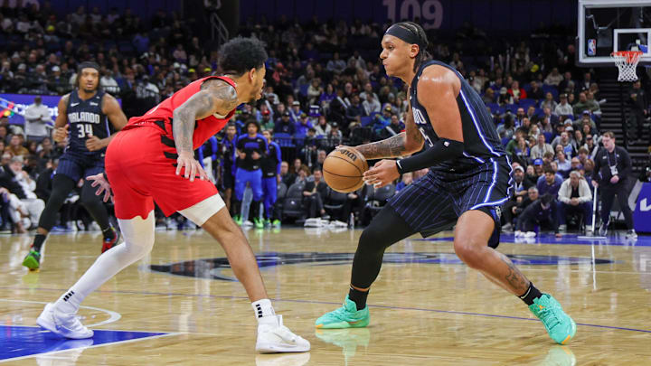 Orlando Magic forward Paolo Banchero (5) handles the ball in front of Portland Trail Blazers guard Anfernee Simons (1) during the second quarter at Kia Center.