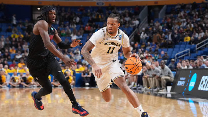 Mar 19, 2026; Buffalo, NY, USA; Michigan Wolverines guard Roddy Gayle Jr. (11) drives to the basket against Howard Bison guard Alex Cotton (4) during a first round game of the men's 2026 NCAA Tournament at Keybank Center. Mandatory Credit: Gregory Fisher-Imagn Images