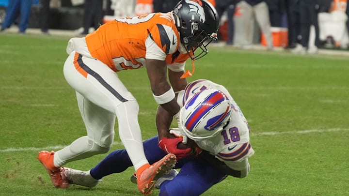 Denver Broncos cornerback Ja'Quan McMillian reaches in on Buffalo Bills wide receiver Brandin Cooks, who has the ball and whose knee is on the ground during overtime at Empower Field at Mile High in Denver, Colorado on Jan. 17, 2026.