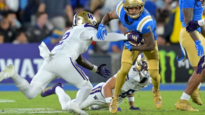 The Huskies' Rahshawn Clark (2) forces a fumble by UCLA wide receiver Mikey Matthews (7).