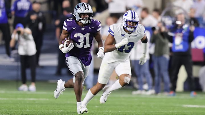 Sep 21, 2024; Provo, Utah, USA; Kansas State Wildcats running back DJ Giddens (31) runs the ball against Brigham Young Cougars defensive end Isaiah Bagnah (13) during the third quarter at LaVell Edwards Stadium. Mandatory Credit: Rob Gray-Imagn Images