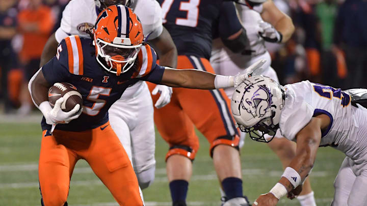 Aug 29, 2025; Champaign, Illinois, USA;  Illinois Fighting Illini running back Ca'Lil Valentine (5) stiff arms Western Illinois Leathernecks defensive back Christian Pierce (3) during the second half at Memorial Stadium. Mandatory Credit: Ron Johnson-Imagn Images