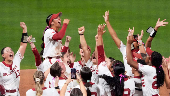 Oklahoma lifts Ailana Agbayani (50) in the air after she was awarded an AUSLU Golden Ticket during the college softball game between the Sooners and Georgia.