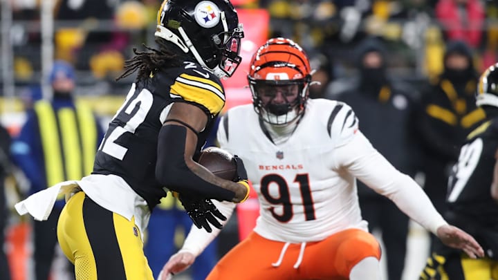 Steelers running back Najee Harris (22) runs the ball as Bengals defensive end Trey Hendrickson (91) defends 