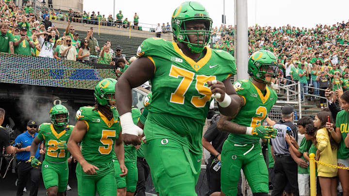 Oregon’s Emmanuel Pregnon, center, takes the field before the game against Oklahoma State at Autzen.