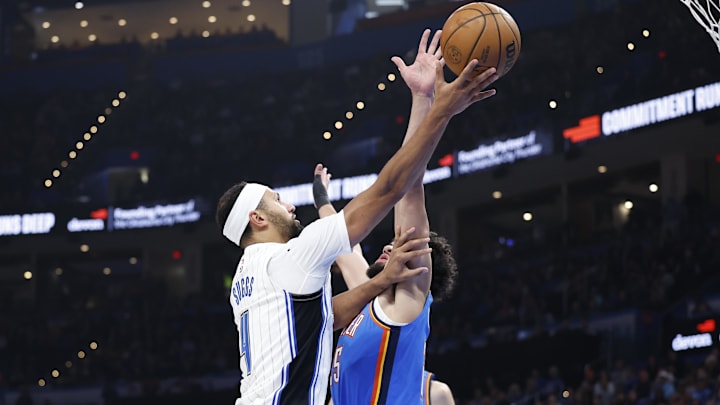 Orlando Magic guard Jalen Suggs (4) shoots as Oklahoma City Thunder guard Ajay Mitchell (25) defends during the second quarter at Paycom Center.